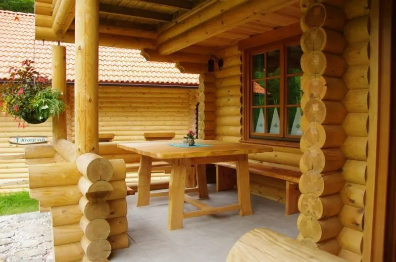 Überdachte Terrasse mit großem Holztisch am Chalet