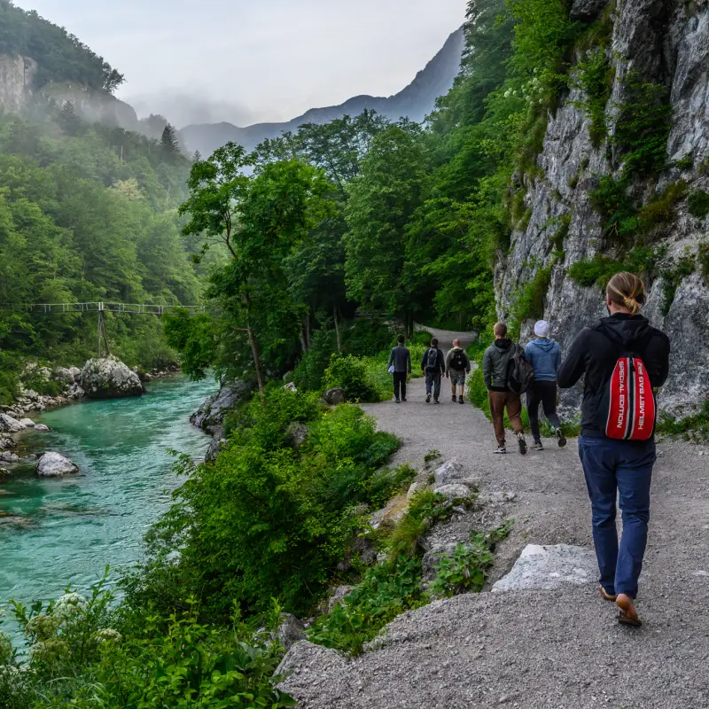 Die Gruppe wandert am türkisen Wasser der Soča entlang